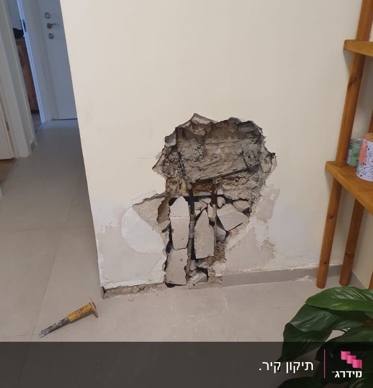 קיר עם חור גדול, כלי עבודה על הרצפה